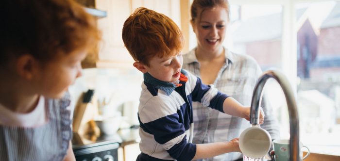 A family washing up at the sink together