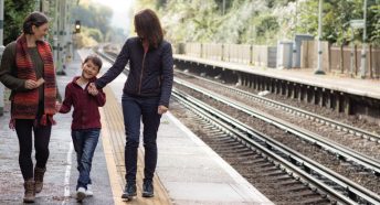 A family walking along the platform of a rural train station