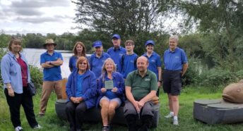 A group of volunteers, with a lake behind.