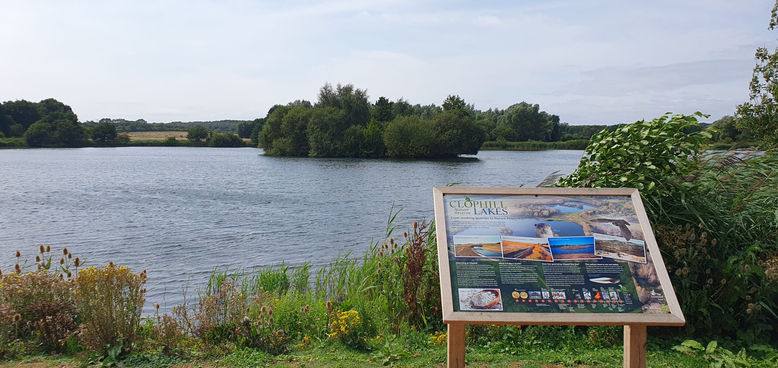 A lake with visitor interpretation board in the foreground.