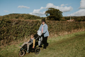 Grandmother walking with child in a pushchair