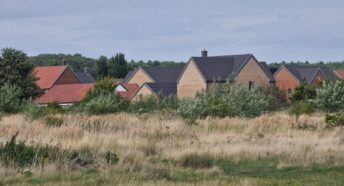 View of new houses with rough grassland in front