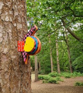 Painted wooden snail attached to a tree trunk